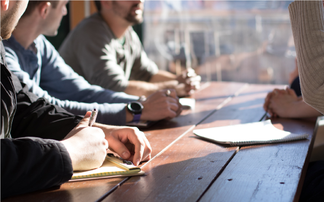 people sitting at table writing