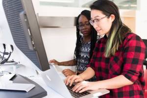asian woman and black woman at a computer