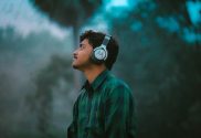 person with headphones on; top podcasts