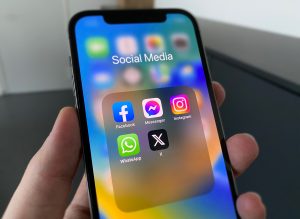 A picture of a phone with social media apps from X, Instagram, Whatsapp and Facebook