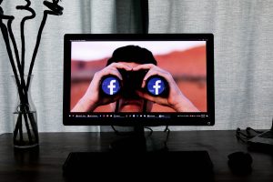 Photo of computer screen showing binoculars with Facebook's logo
