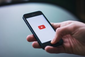 Picture of someone holding a phone with YouTube app open