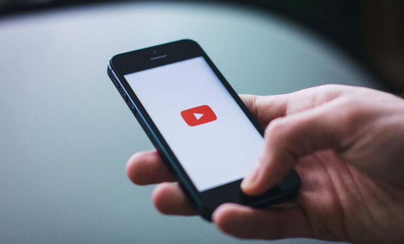 Picture of someone holding a phone with YouTube app open