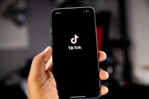 A photo of the TikTok app being opened on a mobile phone