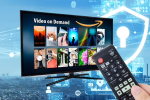 Amazon Fire TV software update disrupts apps. Person holds remote, points at TV with on demand apps and Amazon logo. Blue background depicts cybersecurity situation