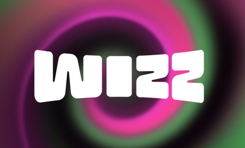 An image of the Wizz app logo. White lettering for the word 'Wizz' on a swirling background of pink, black and green colours.