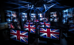 black background, computer screens with distorted faces, UK flags on some screens.