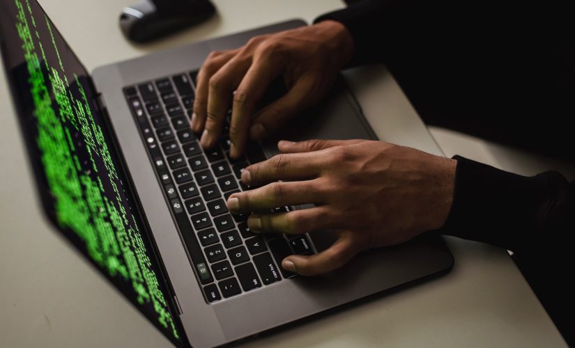 Hacker man's hands on green screen laptop