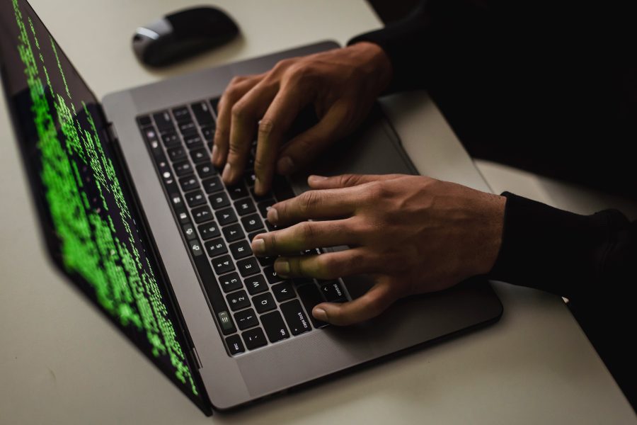 Hacker man's hands on green screen laptop