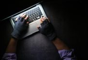 a person with fingerless gloves on a laptop keyboard