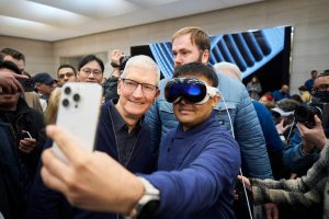 Tim Cook takes a selfie with someone wearing an Apple Vision Pro