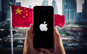 An iPhone with Apple logo on screen against a backdrop of a Chinese city where a Chinese flag can be seen.
