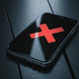 iPhone on a black background with a red "X"