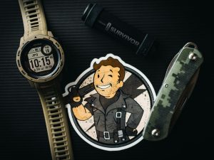Fallout 5: Fallout man on a sticker, with a watch and survival tools surrounding it