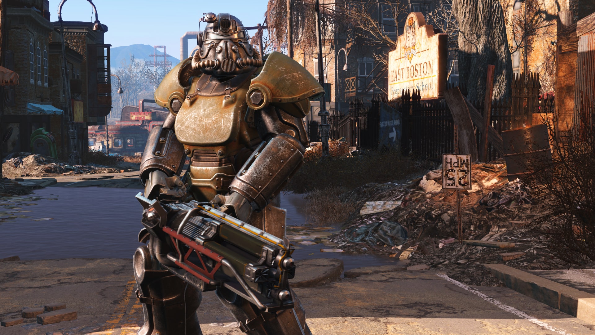 An in-game image from Fallout 4. A game character holds a large two handed gun. They are wearing metal 'power amor' all over their body.