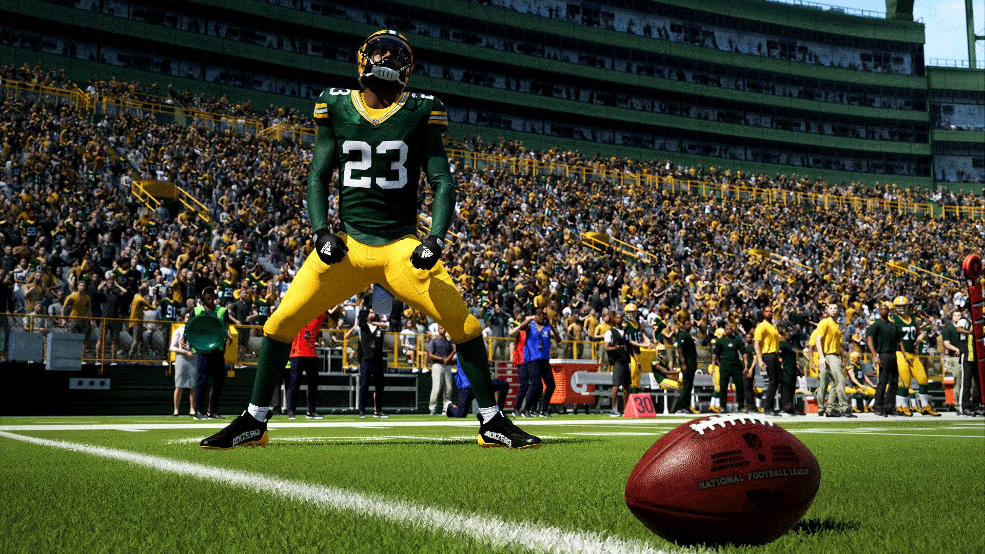 Een verdedigende speler van Green Bay Packers viert een stop op de achtergrond, terwijl de voetbal centimeters van de doellijn op de voorgrond wordt weergegeven, in een schermopname van Madden NFL 24