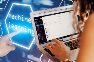 Slack faces backlash over user data used for AI and machine learning training. A person using a laptop with Slack open on the screen, while a hand points to a glowing "machine learning" icon on a digital interface in the background. The image highlights the controversy over Slack's use of customer data for AI and machine learning training.