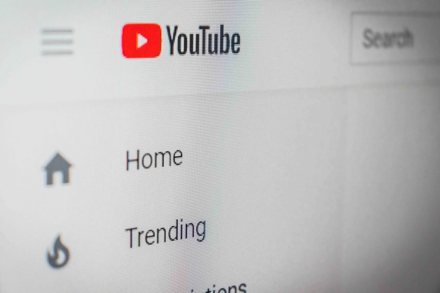 Close up of the YouTube Home Screen, showing the logo on the left hand corner along with the menu options below - like Home and Trending. The Search feature is just to the right of the image.