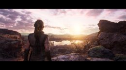 A screenshot from the upcoming game Hellblade 2: Senua's Saga. It shows a beautiful sunset on the horizon, with protagonist Senua stood with her back to the camera in the foreground.