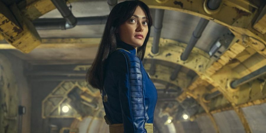 Ella Purnell as Lucy MacLean, dweller of Vault 33 in Amazon Prime TV's Fallout television show. She is turning her head over her right shoulder gazing back at the vault she is about to leave.