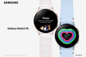 Samsung launches Galaxy Watch FE - its new affordable wearable. The image shows an advertisement for the Samsung Galaxy Watch FE. It features two different watch models, both with round faces and sleek designs. The watch on the left is pink with a white strap and displays a 