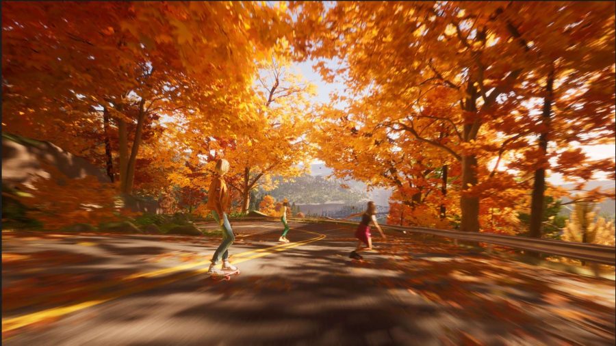 A screenshot from Mixtape - three teenagers skateboard down a road. It's surrounded by orange and golden leafed trees.