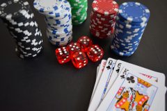 Image of dice, chips and cards on gambling table / Indonesian government has renewed its crackdown on illegal online gambling.