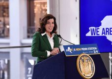 New York Governor Kathy Hochul stood behind a podium before a speech in New York. Inside a building and in front of a window.