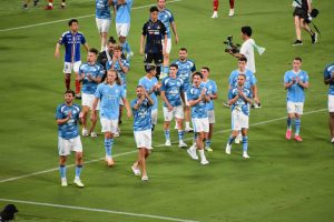 Manchester City footballers on the pitch in 2023. Can see them clapping and looking at fans after a game.