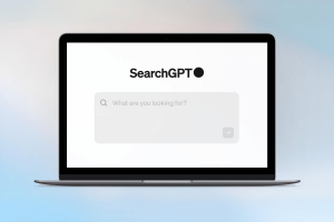 OpenAI launches AI engine SearchGPT to rival Google's Gemini. A laptop displaying the SearchGPT interface with a minimalist design, featuring a prominent SearchGPT logo and a search bar asking "What are you looking for?". The background is a soft gradient.