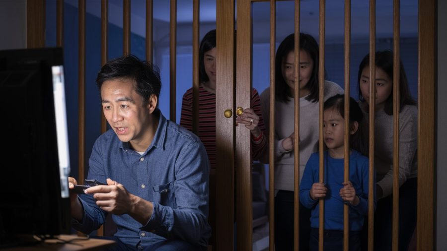 An image of a family shut behind a gate while the father plays games because of no family pass