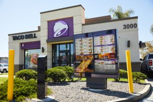 Shot of outside of a Taco Bell with an AI automated chatbot at the front of the drive thru