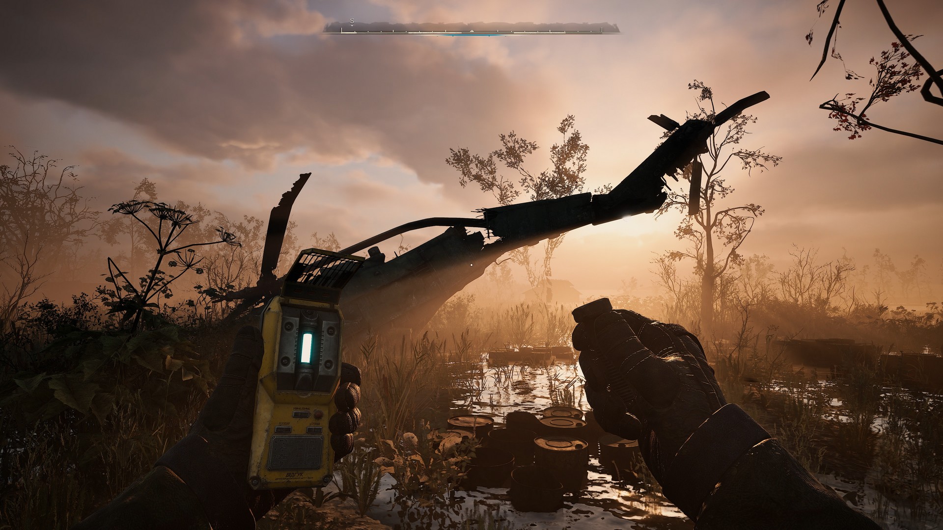  Heart of Chornobyl; the player has an anomaly detector out and is scanning for clues to hidden loot. The rusted out hulk of a downed helicopter is in the distance.