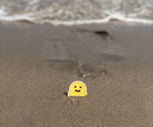 Logo Hugging Face sur une plage.