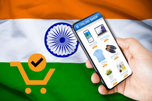 India accuses smartphone firms of colluding with Amazon and Flipkart, breaching antitrust laws. Person on online shopping app on smartphone in front of Indian flag and orange basket graphic