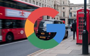 A Google logo with the UK flag colors on the first 'G'. The background is a UK city street with red double-decker buses, black cabs, and phone booths. There's a pedestrian walking on the sidewalk.