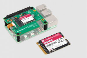 The image depicts a Raspberry Pi single-board computer with an M.2 HAT attached. The HAT (Hardware Attached on Top) is labeled Raspberry Pi M.2 HAT; and it supports an M.2 key slot, which is a standardized slot for attaching M.2 SSDs or other compatible devices. Raspberry Pi launches branded NVMe SSDs and ready-to-use SSD kits