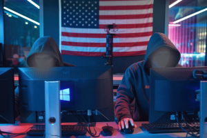 Russian hackers intensify spear-phishing attacks on US targets, Microsoft warns. Russian hooded hackers using Microsoft windows computers with US flag in the background