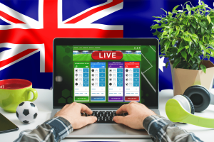 A third of Australians gamble on sports, survey shows. Person on a computer betting on a sports match with an Australian flag in the background