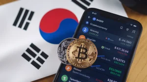 A photo of a smartphone screen displaying the cryptocurrency exchange platform, with various cryptocurrencies listed. The South Korea flag is displayed in the background. The overall scene is well-lit and clear.