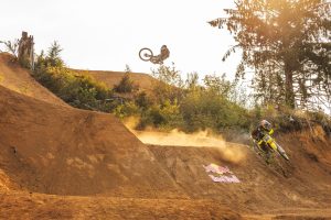 Carson Storch and Carson Brown ride the downhill course in Pacific City, Oregon on September, 7 2024. Bike and person is in the air on the dirt track.