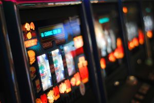 Image of a slot machine in a gambling arcade / Gambling Industry fines drop by 73.3% across 2024.