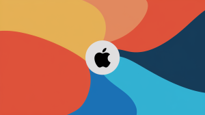 An illustration of the Apple logo on a dynamic background. The background consists of a gradient of orange, yellow, and blue colors, transitioning from the bottom left to the top right. The Apple logo is placed on a white circle, centered on the background.