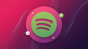 A dynamic background with a gradient of pink and purple. There is a large Spotify logo in the center. The logo has a vibrant green color and is placed on a white circle. The white circle is placed on a pink background. There are small white circles with green checkmarks scattered around the logo. The overall image has a modern and clean design.