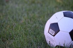 Close-up of a football positioned on grass.