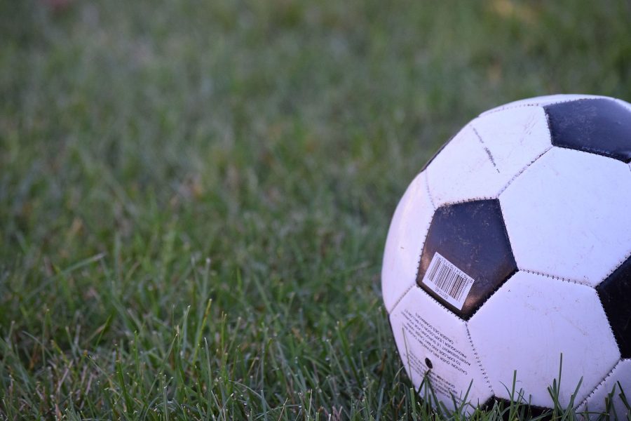 Close-up of a football positioned on grass.