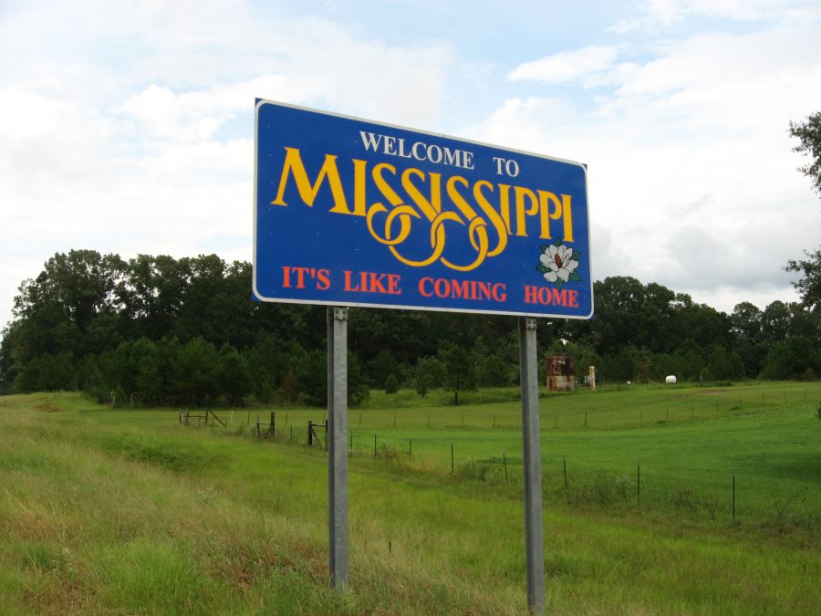 Trees in the background, with a Mississippi sign saying 'Welcome to Mississippi' in blue.
