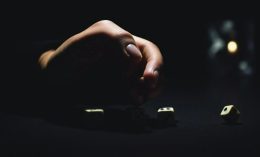 A hand in a dark room over dice