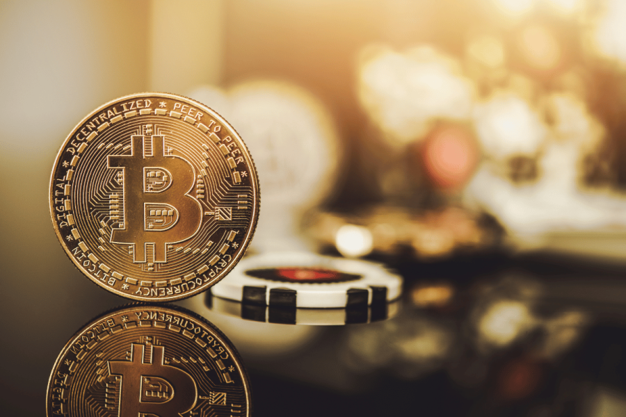 Crypto casinos surge as gamblers bypass bans using offshore sites. Bitcoin token next to casino chips.