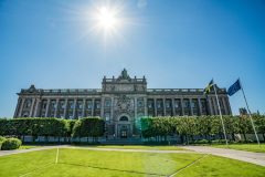 A Stockholm palace in the sunshine with the national and EU flags flowingHacksaw Gaming reportedly exploring IPO in Stockholm